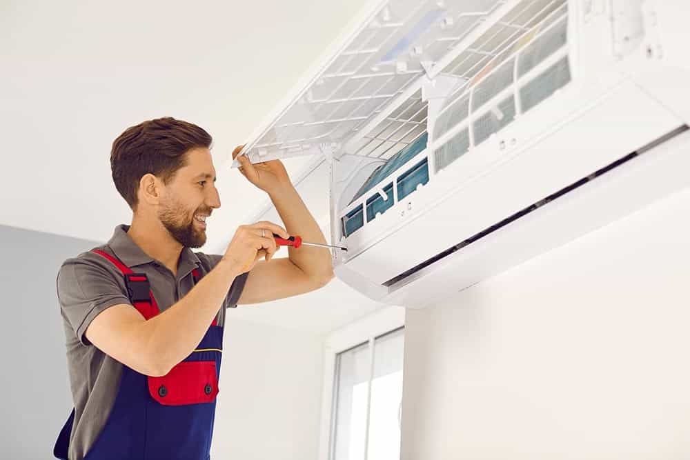 A professional HVAC technician working on an AC unit