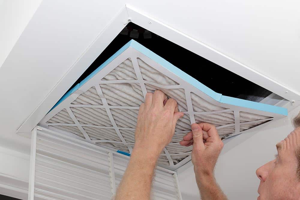 A professional technician using specialized tools to inspect or clean HVAC ductwork.