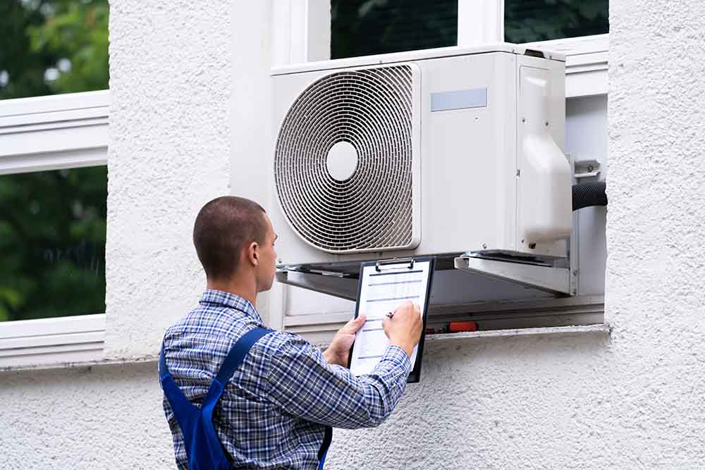A technician inspecting an air conditioning unit, showcasing attention to detail and professionalism.