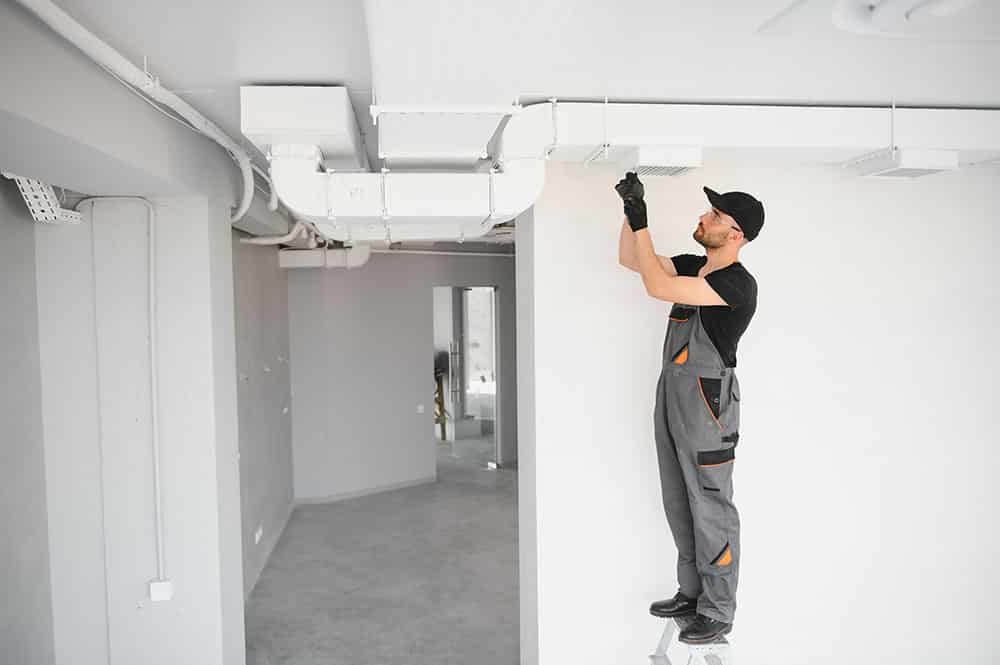 A technician cleaning HVAC ducts with specialized equipment, showcasing the process in action.