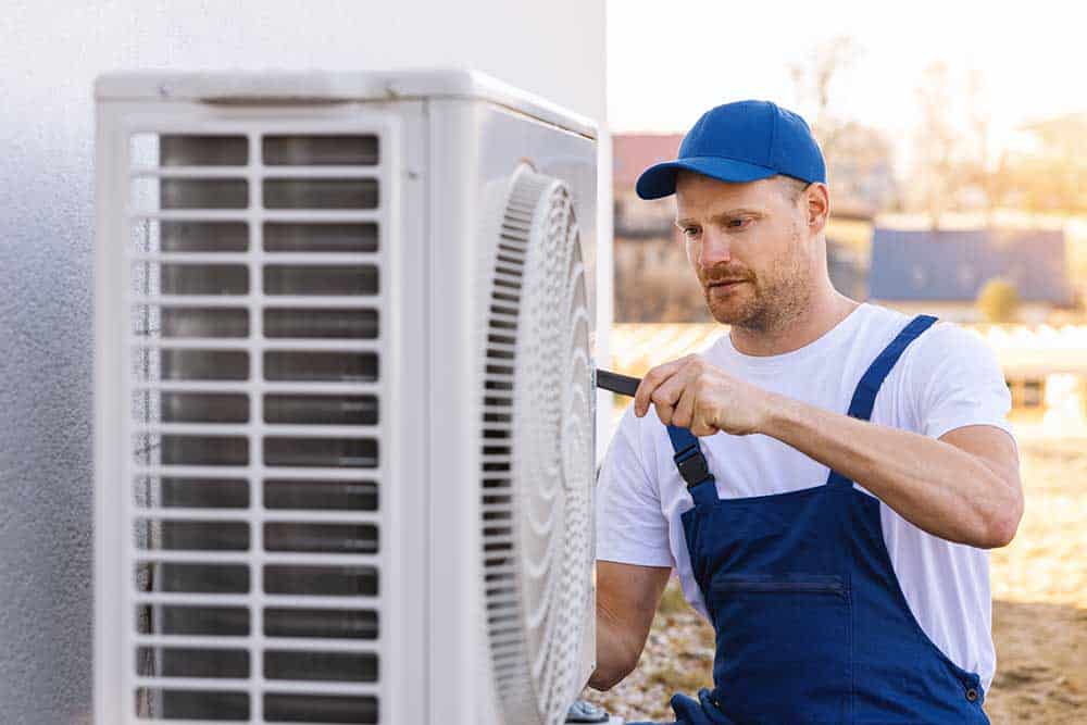 A technician inspecting a modern HVAC system, with tools and equipment neatly organized nearby.