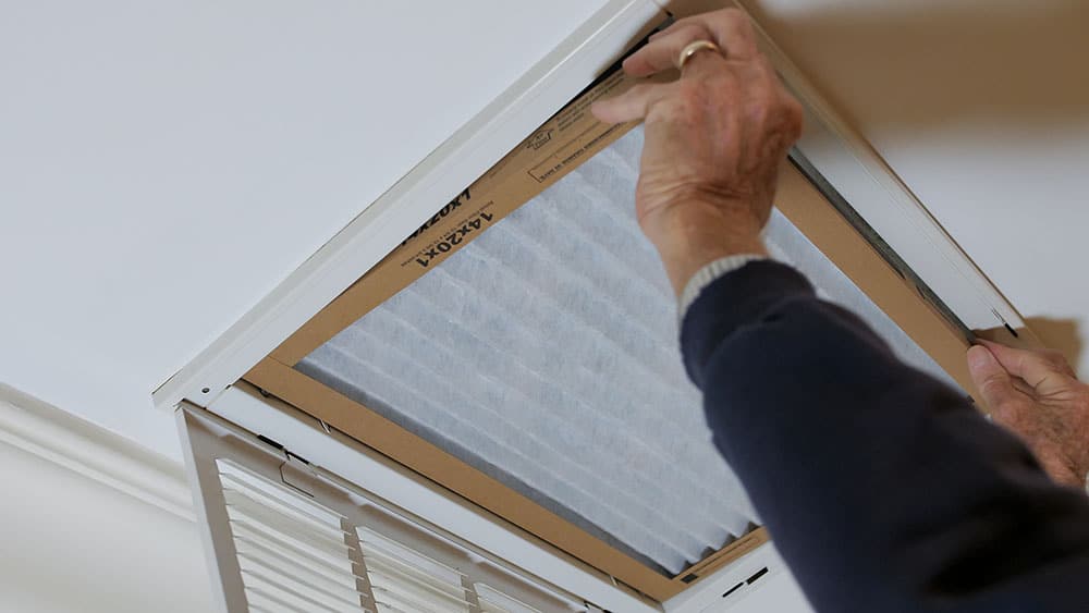 Technician replacing a dusty HVAC air filter
