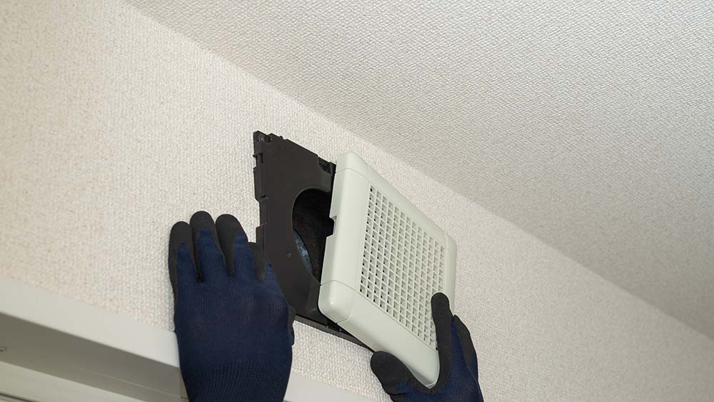 A technician cleaning air ducts in home.