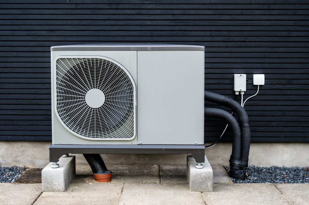 A technician installing a new air conditioner outdoor unit