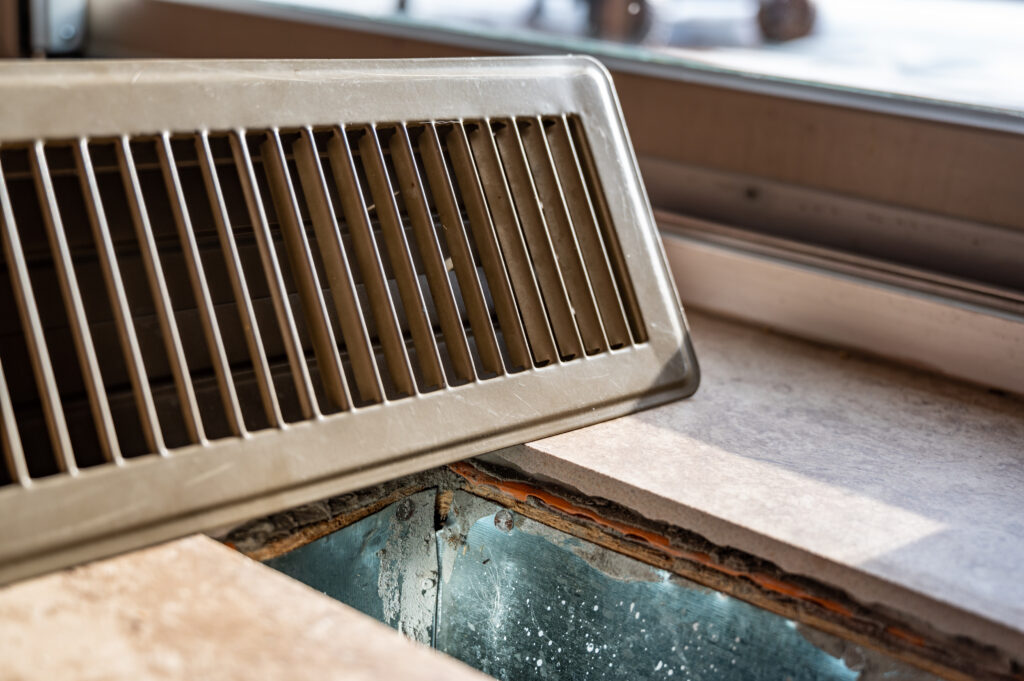 An HVAC technician inspecting a dusty air filter outdoors