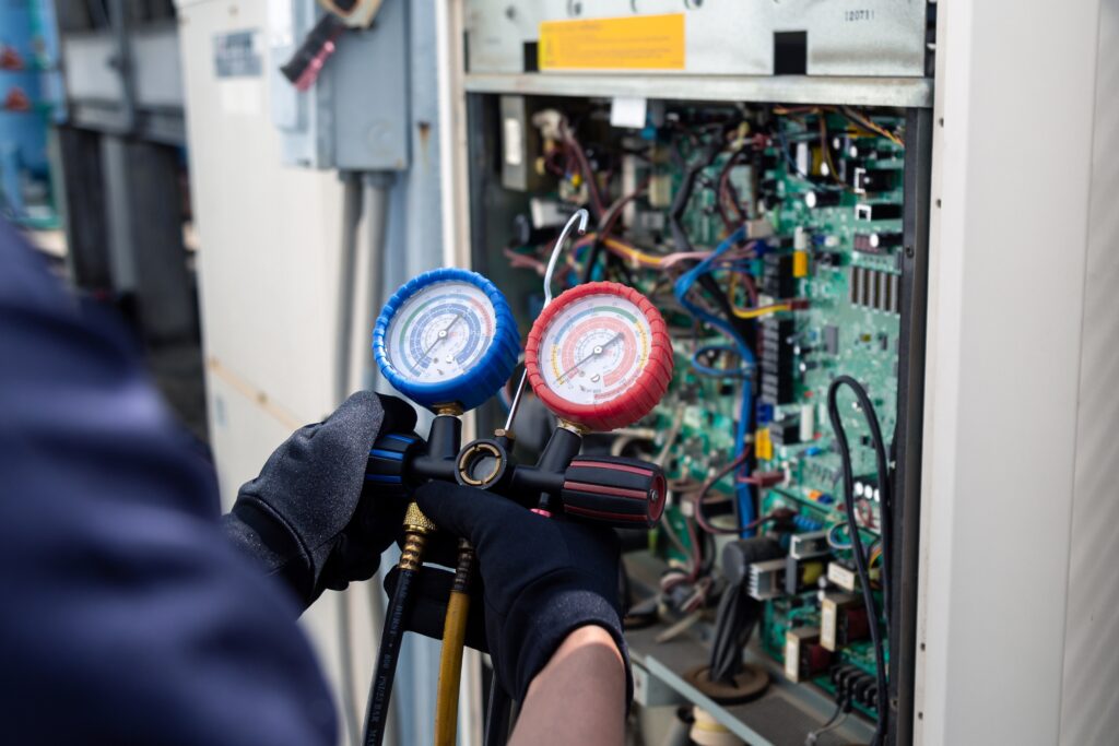 Technician inspecting outdoor air conditioner unit outside home