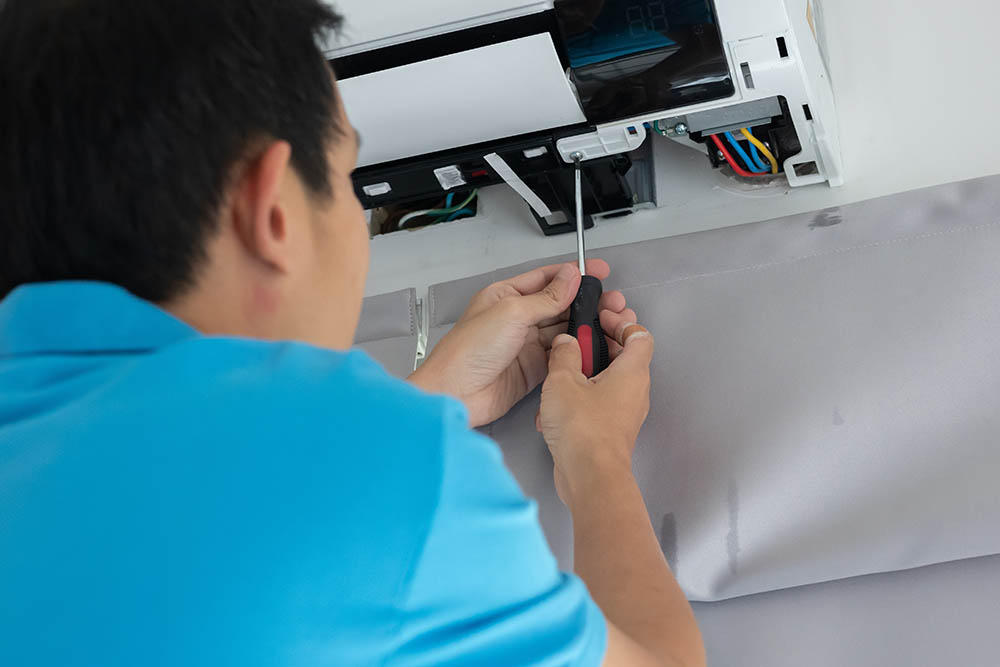Technician installing a residential air conditioner