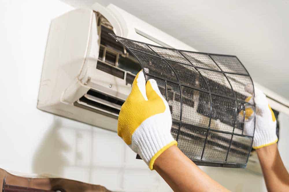 a technician cleaning a dirty air conditioner filter
