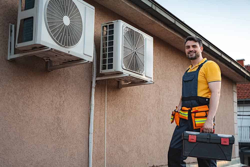 an hvac technician installing a new outdoor condenser unit