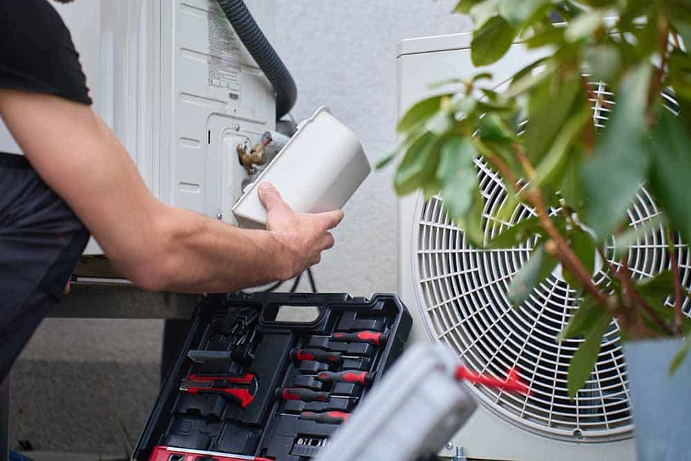 a technician inspecting an outdoor air conditioning unit