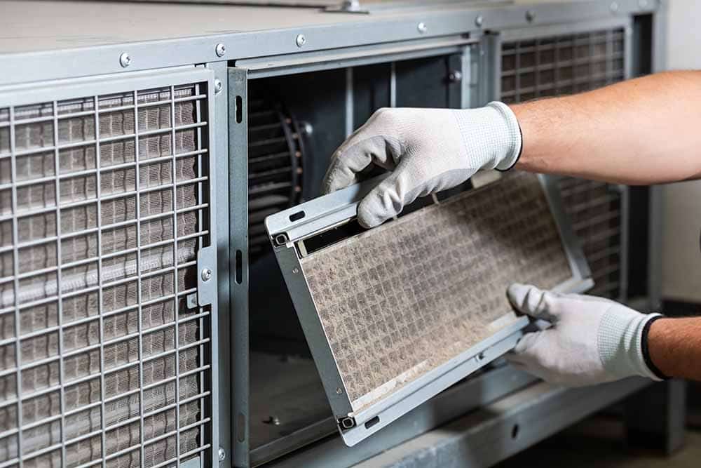 HVAC technician cleaning dusty air duct