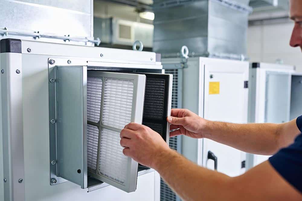 a technician installing a high efficiency air filter