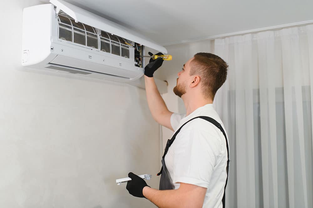 a technician inspecting an air conditioning unit
