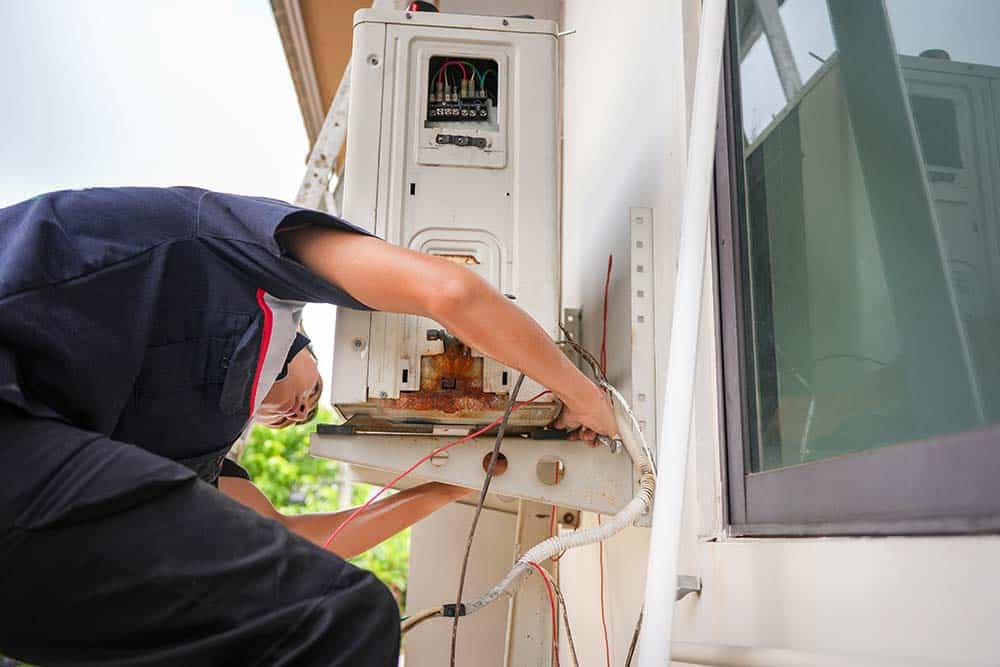 an HVAC technician installing a new outdoor AC unit