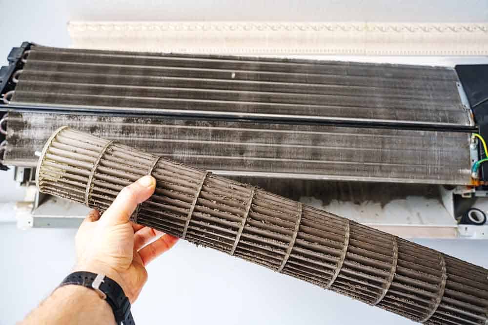 An HVAC technician changing a dirty home air filter