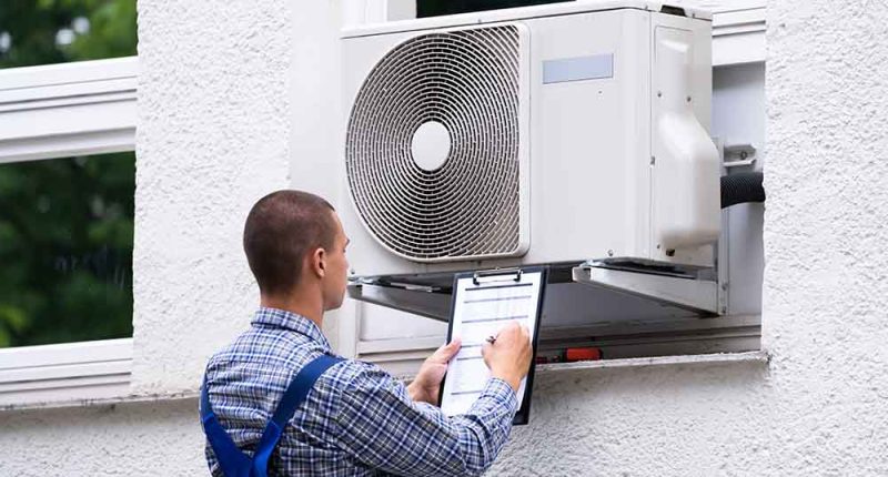 A technician inspecting an air conditioning unit, showcasing attention to detail and professionalism.