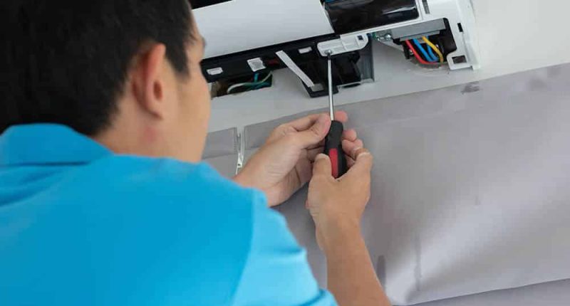A technician performing a detailed inspection of a central AC unit, with tools and equipment neatly organized nearby.