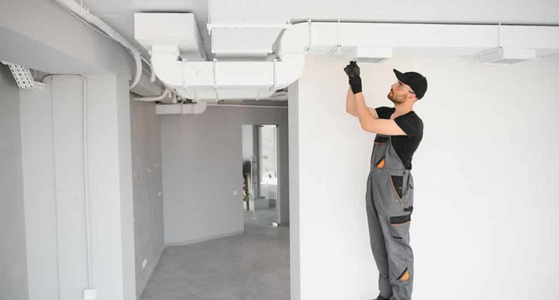 A technician cleaning HVAC ducts with specialized equipment, showcasing the process in action.