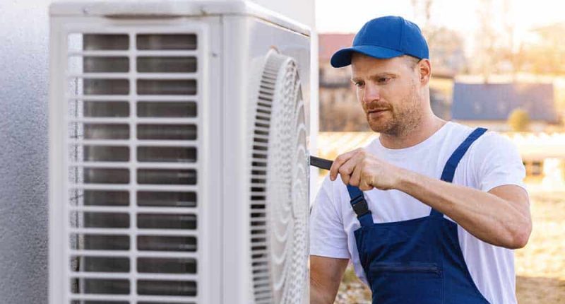 A technician inspecting a modern HVAC system, with tools and equipment neatly organized nearby.