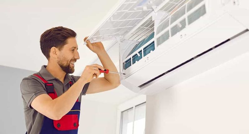 A professional HVAC technician working on an AC unit