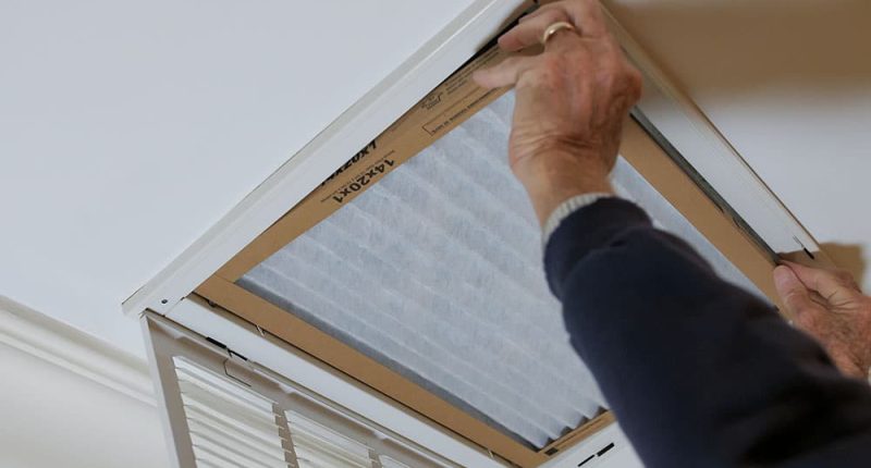 Technician replacing a dusty HVAC air filter Technician replacing a dusty HVAC air filter