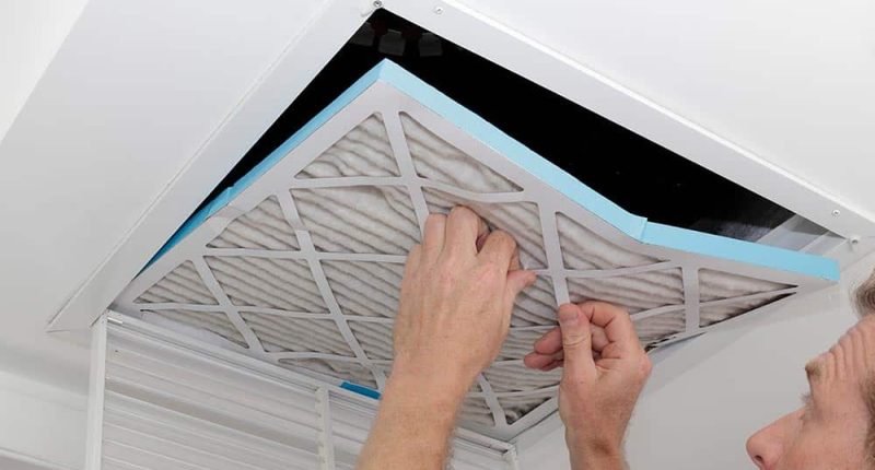 A professional technician using specialized tools to inspect or clean HVAC ductwork.